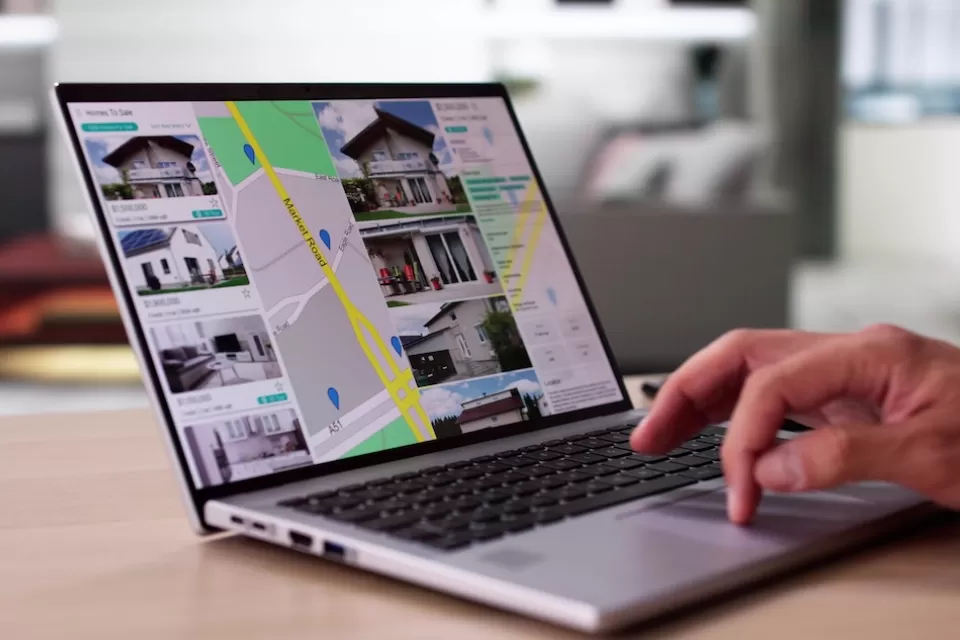 Close-up of laptop with real estate listings shown on map.